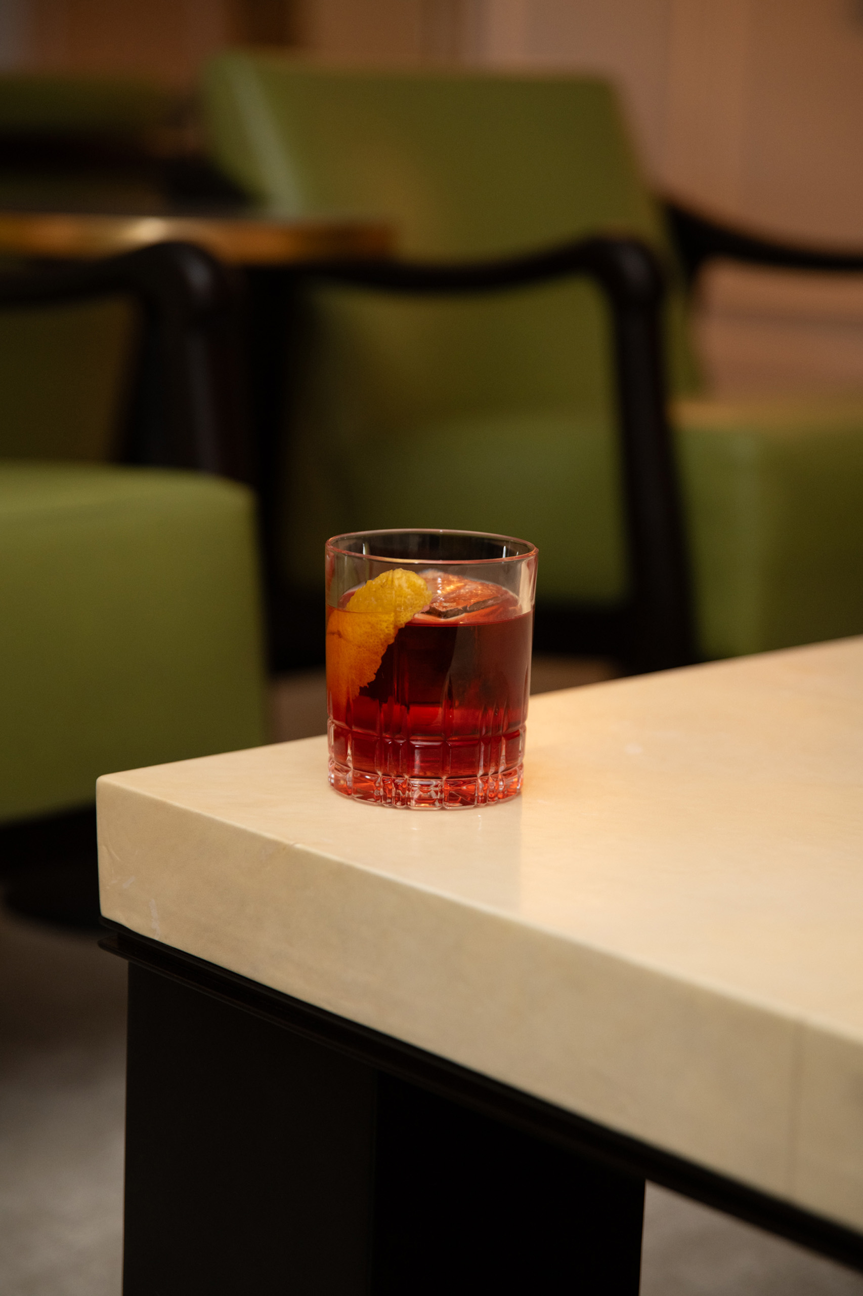 Red cocktail on marble table in lounge.