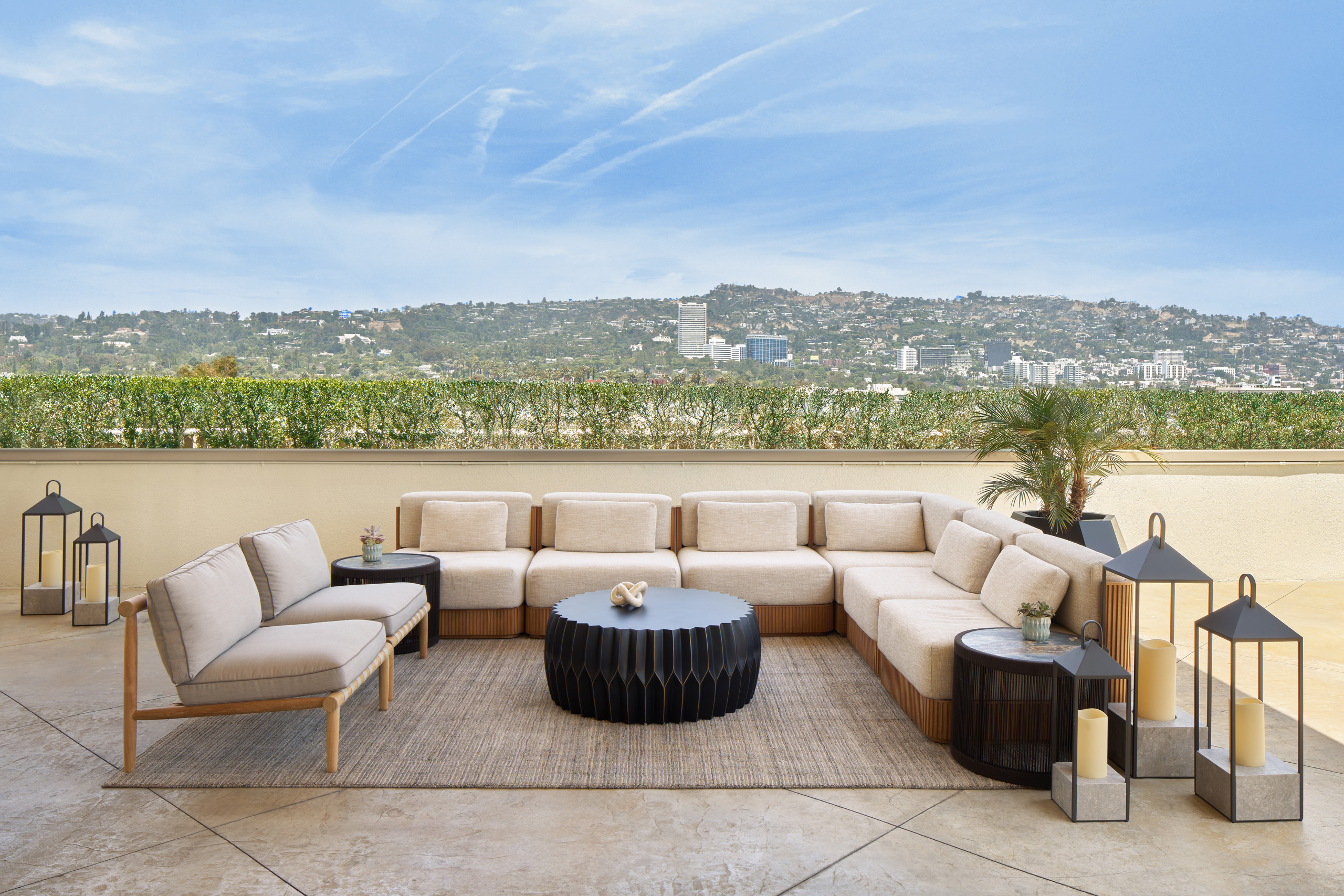 Outdoor sectional seating arranged around a low table with hillside views