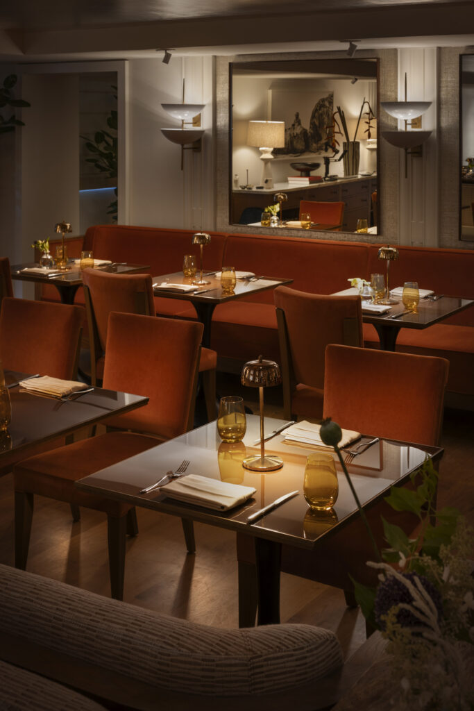 Cozy restaurant dining room with orange banquettes