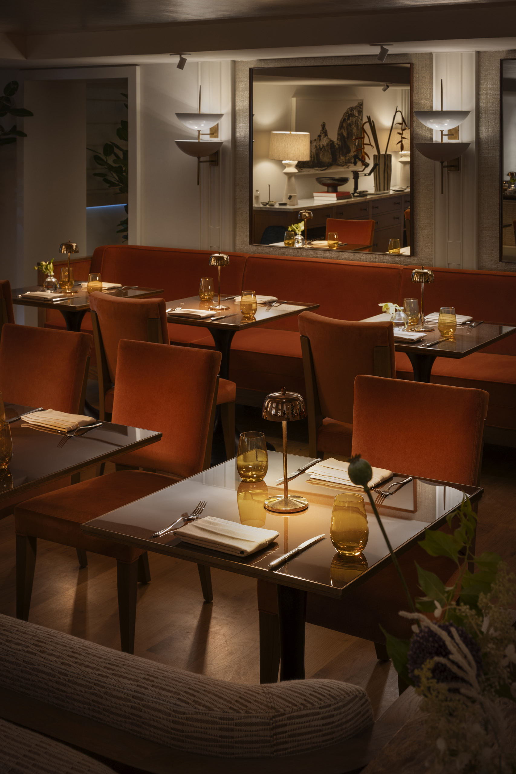 Cozy restaurant dining room with orange banquettes
