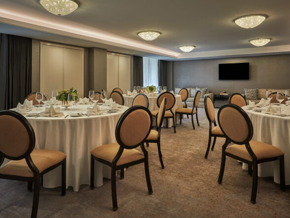 Private dining room with round tables, linens, and chairs.
