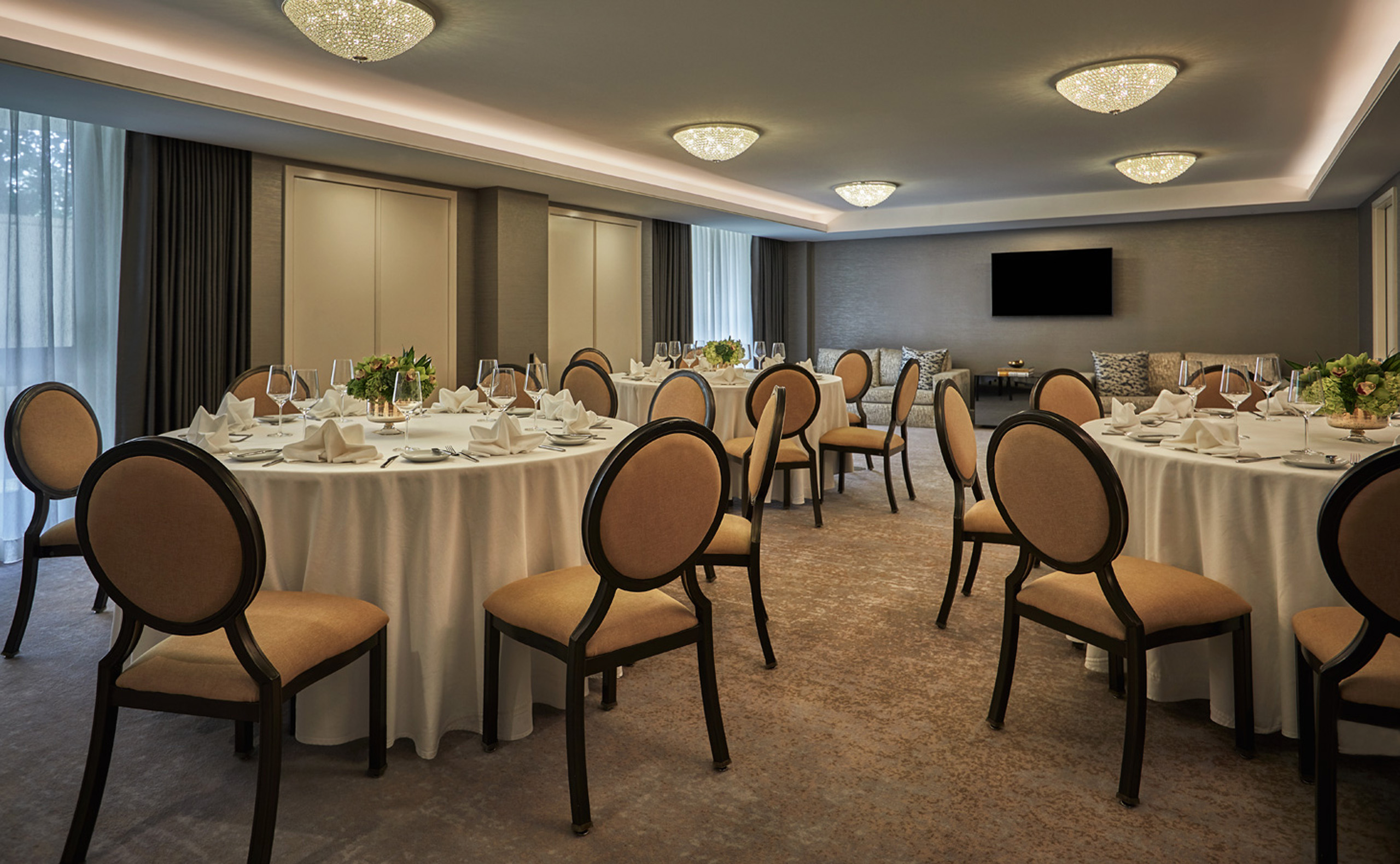 Private dining room with round tables, linens, and chairs.