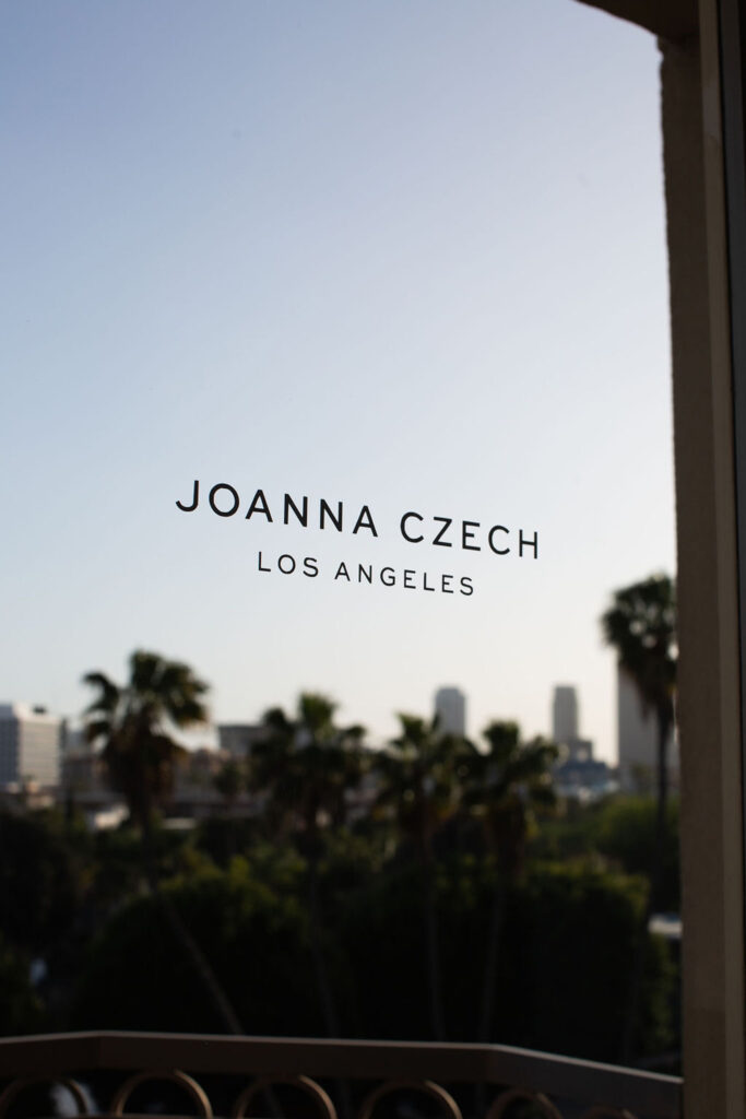 Joanna Czech Los Angeles logo on window with skyline view
