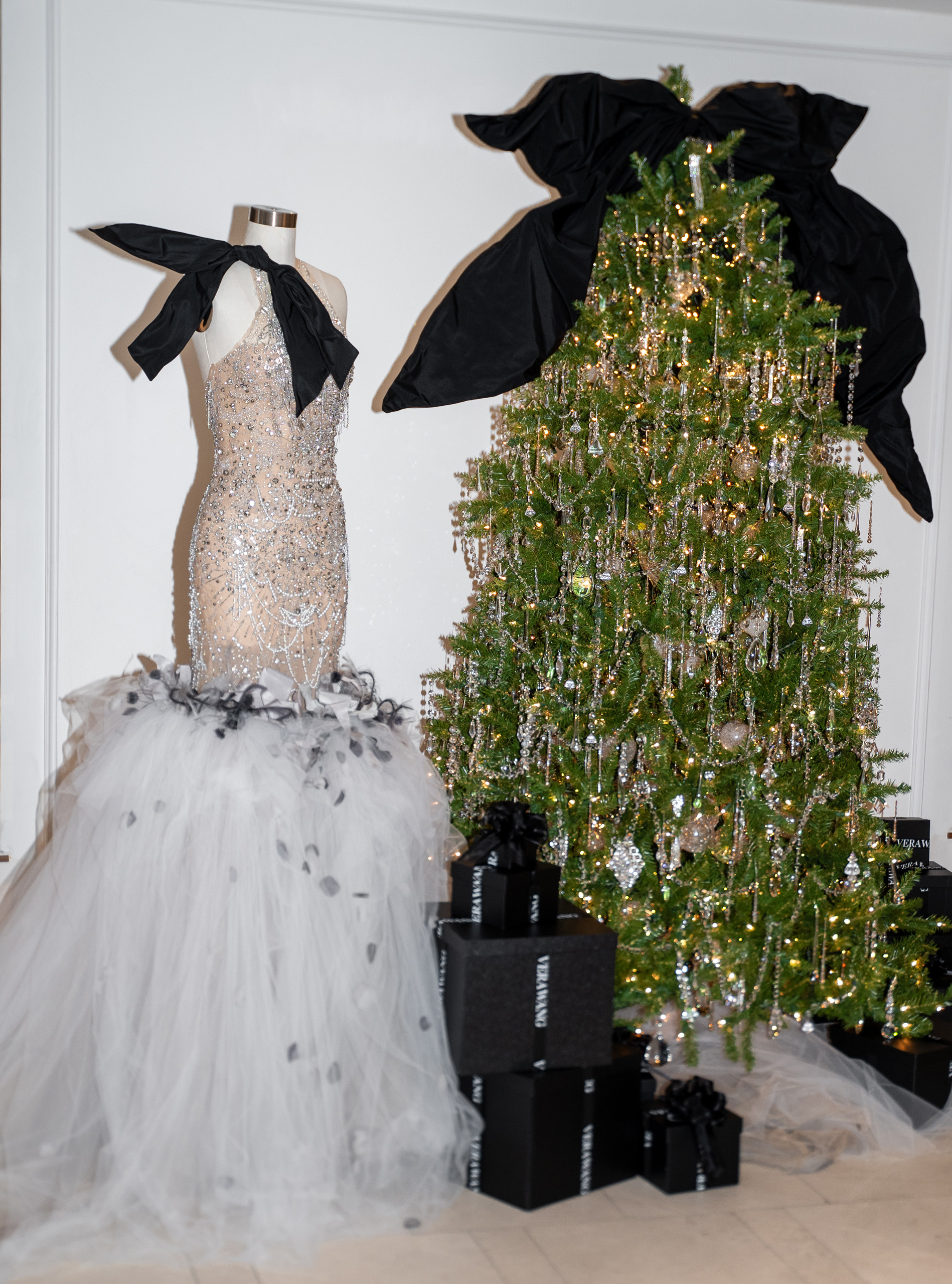 Beaded gown display beside decorated Christmas tree and gifts