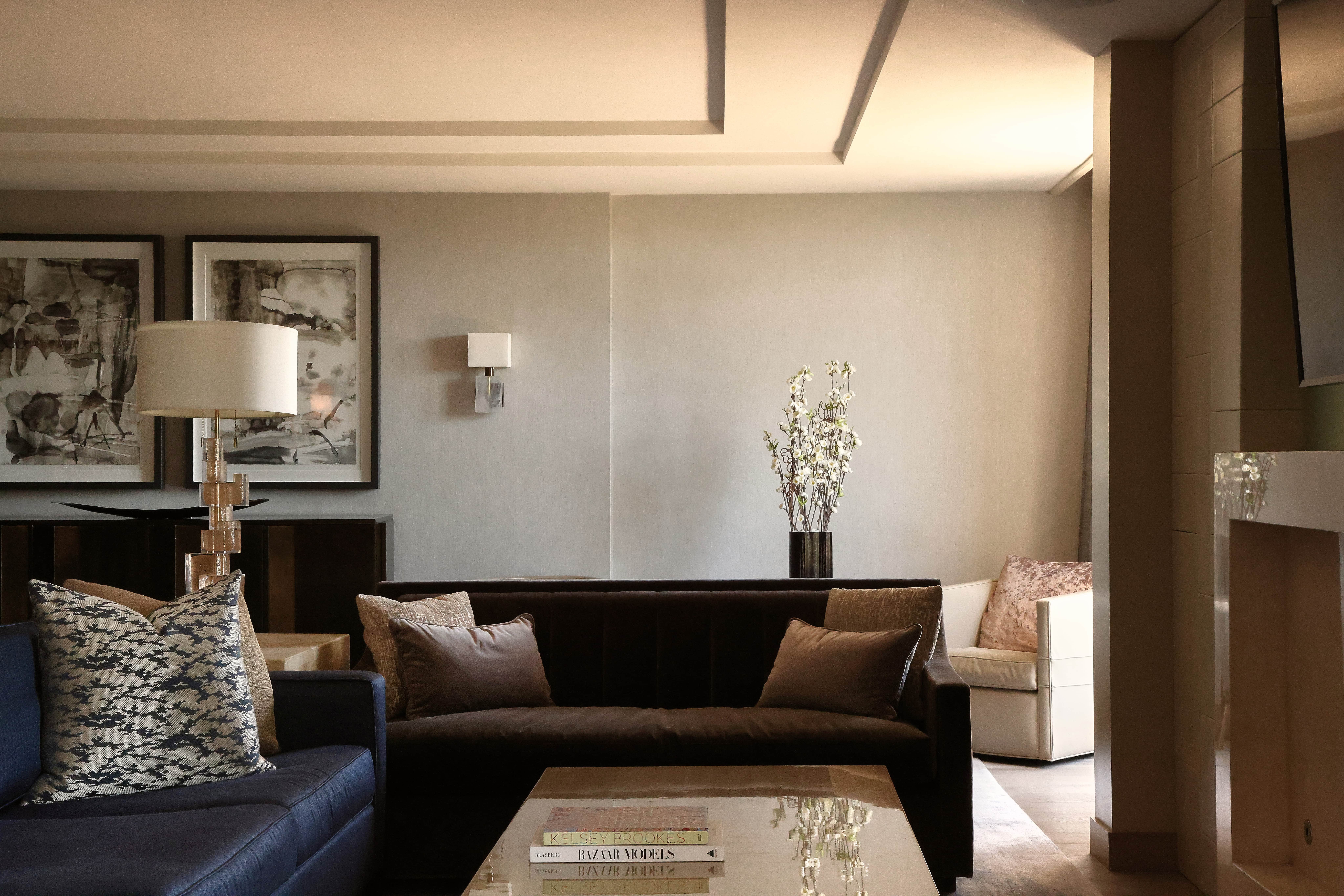 Palm Suite sitting area with layered sofas, framed artwork, and warm neutral decor