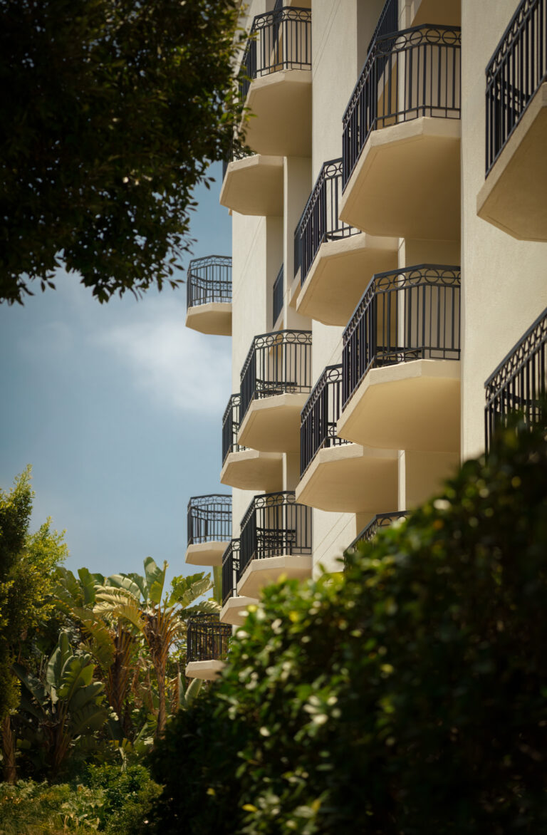 Sunlit balconies framed by lush greenery