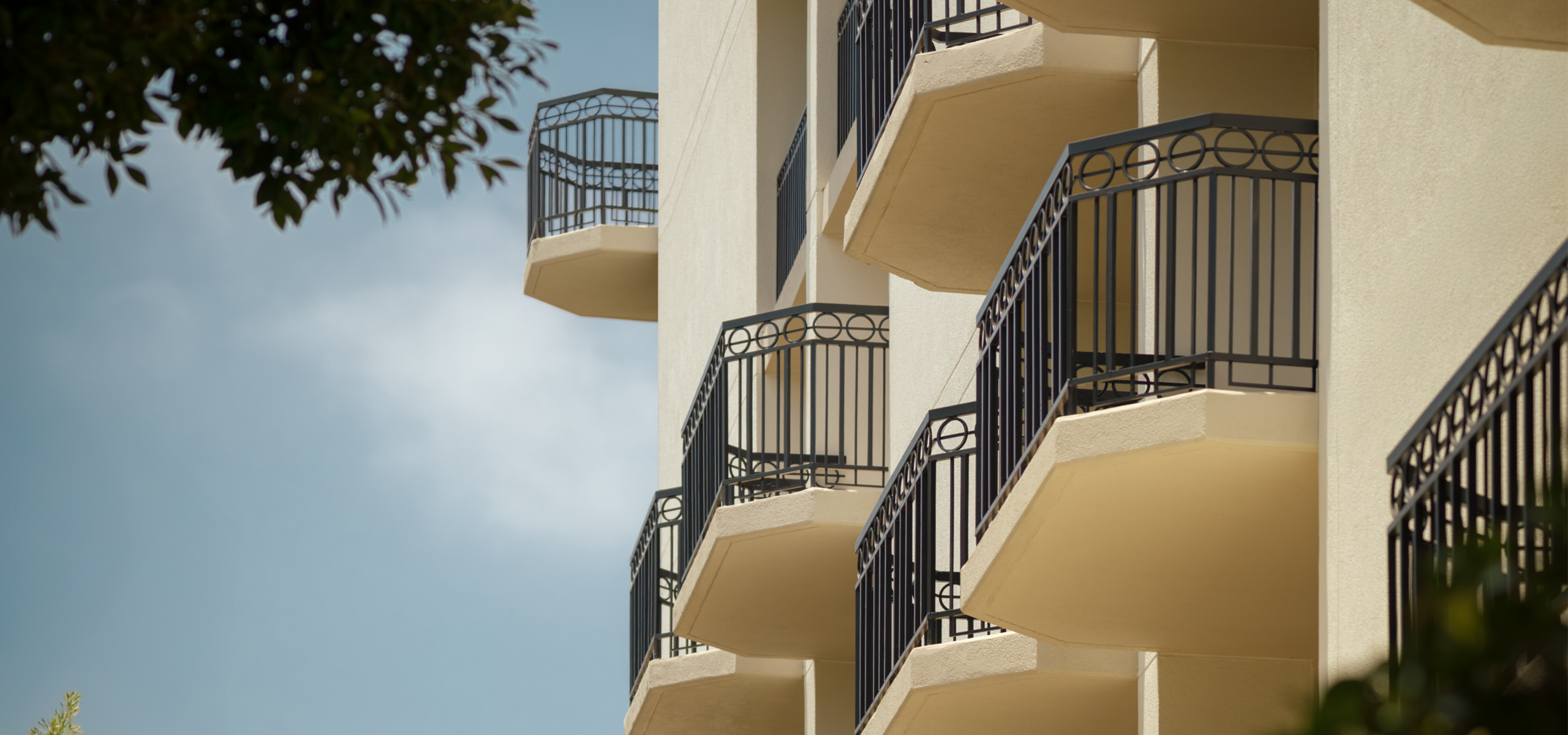 Sunlit balconies framed by lush greenery