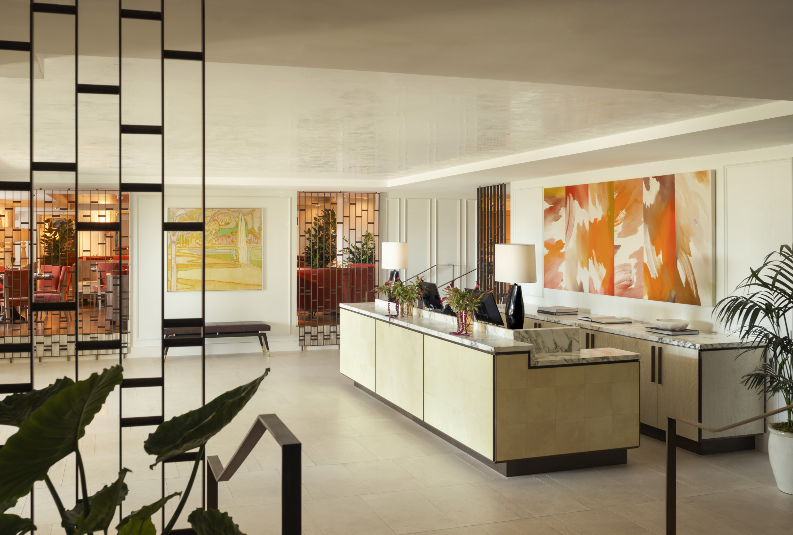 Angled lobby reception desk with plants and modern decor