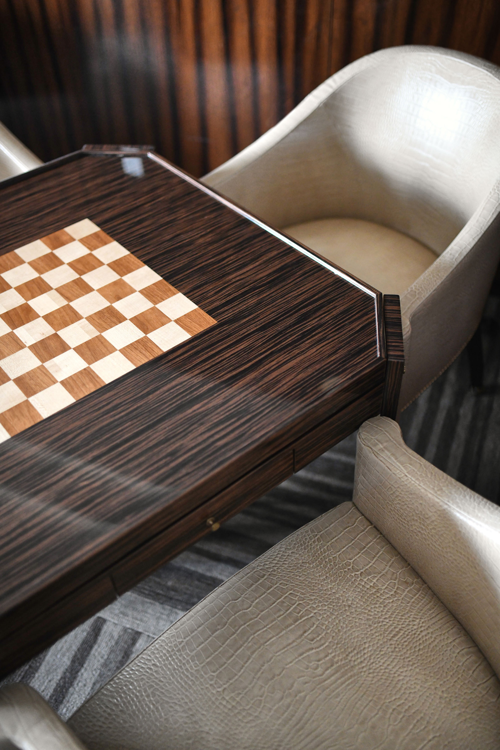 In-suite chess table detail with custom wood finish and plush seating