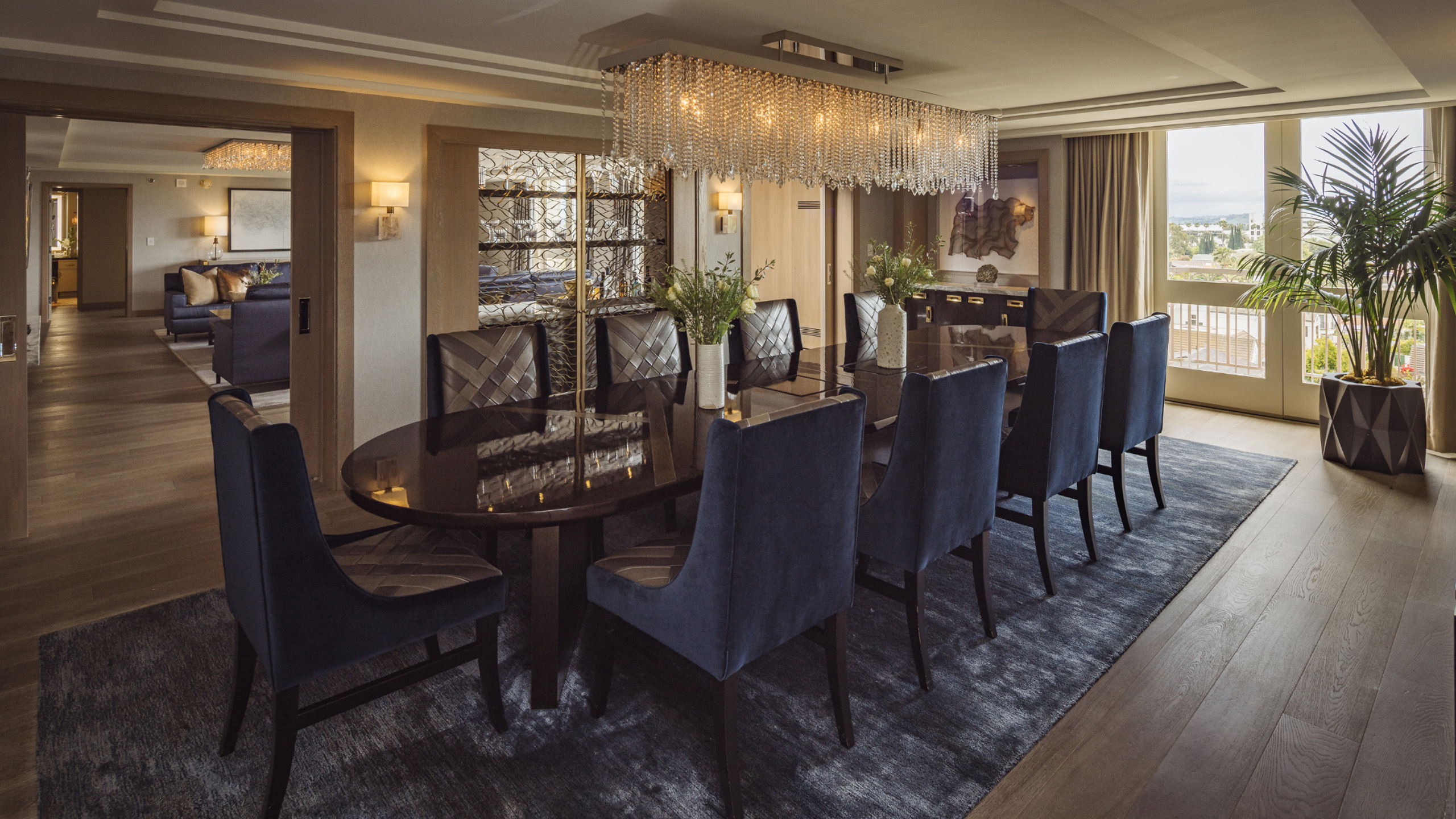 L’Ermitage Suite dining room with oversized chandelier and seating for eight