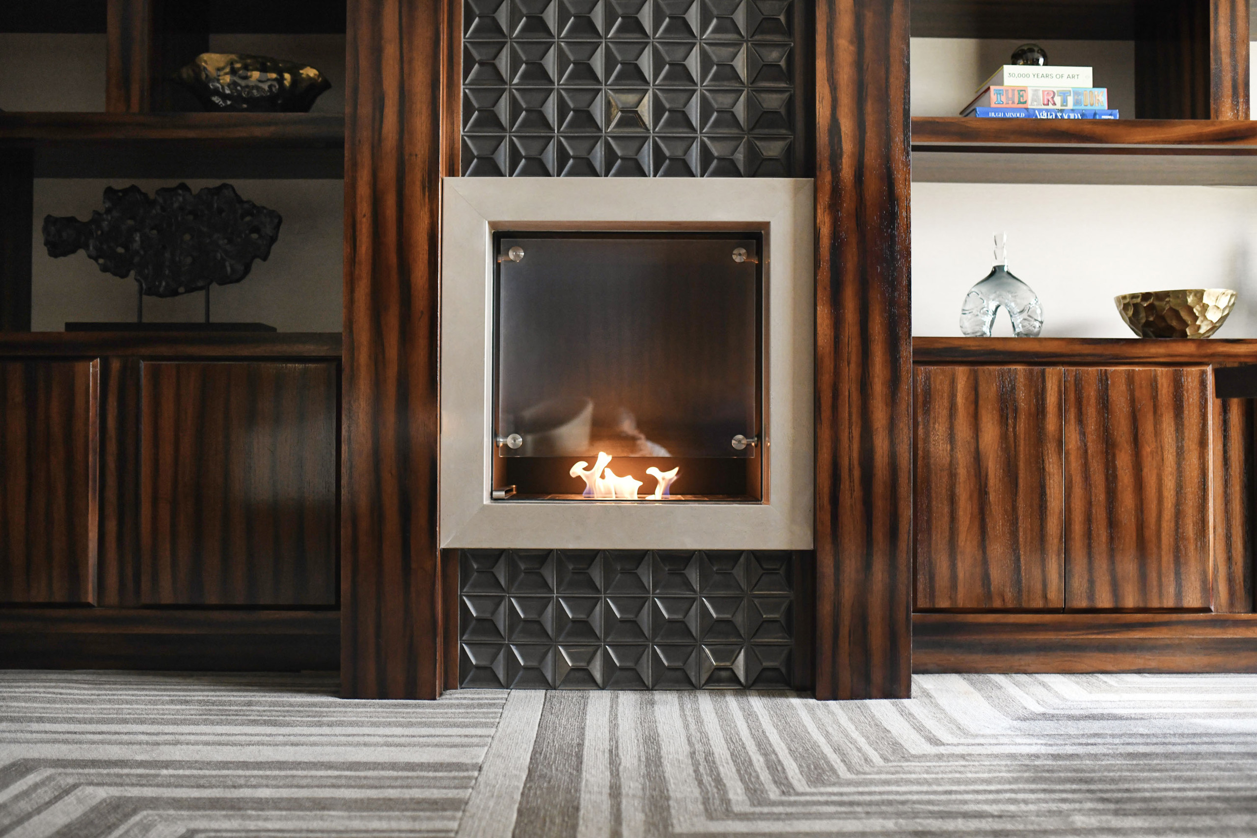 Built-in fireplace with rich wood paneling and display shelving