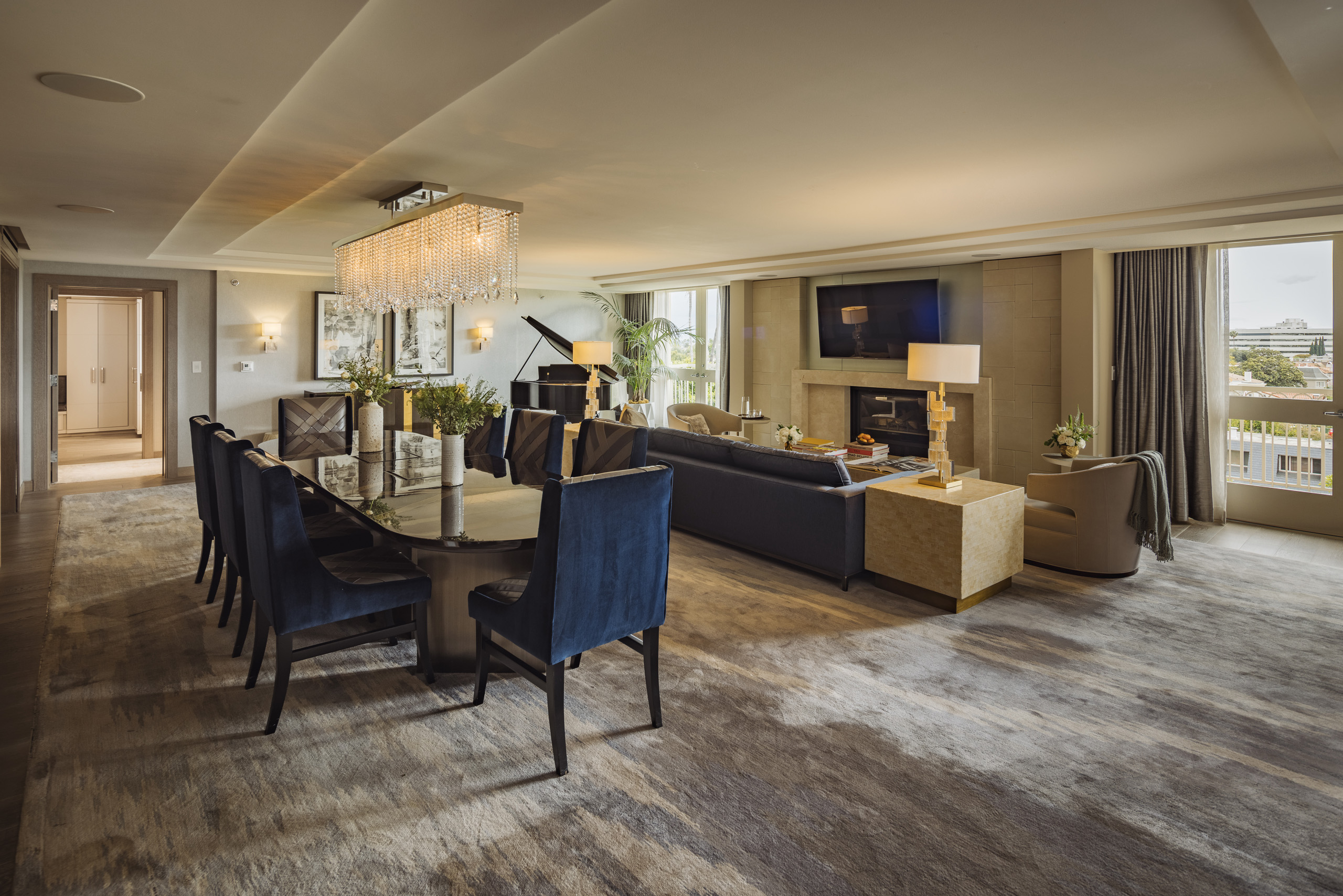 Spacious living and dining suite with chandelier and city views