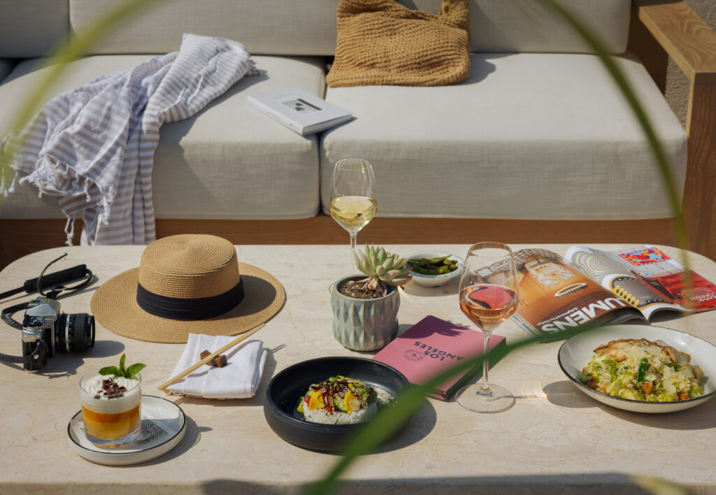 Poolside spread with wine, dessert, and travel items