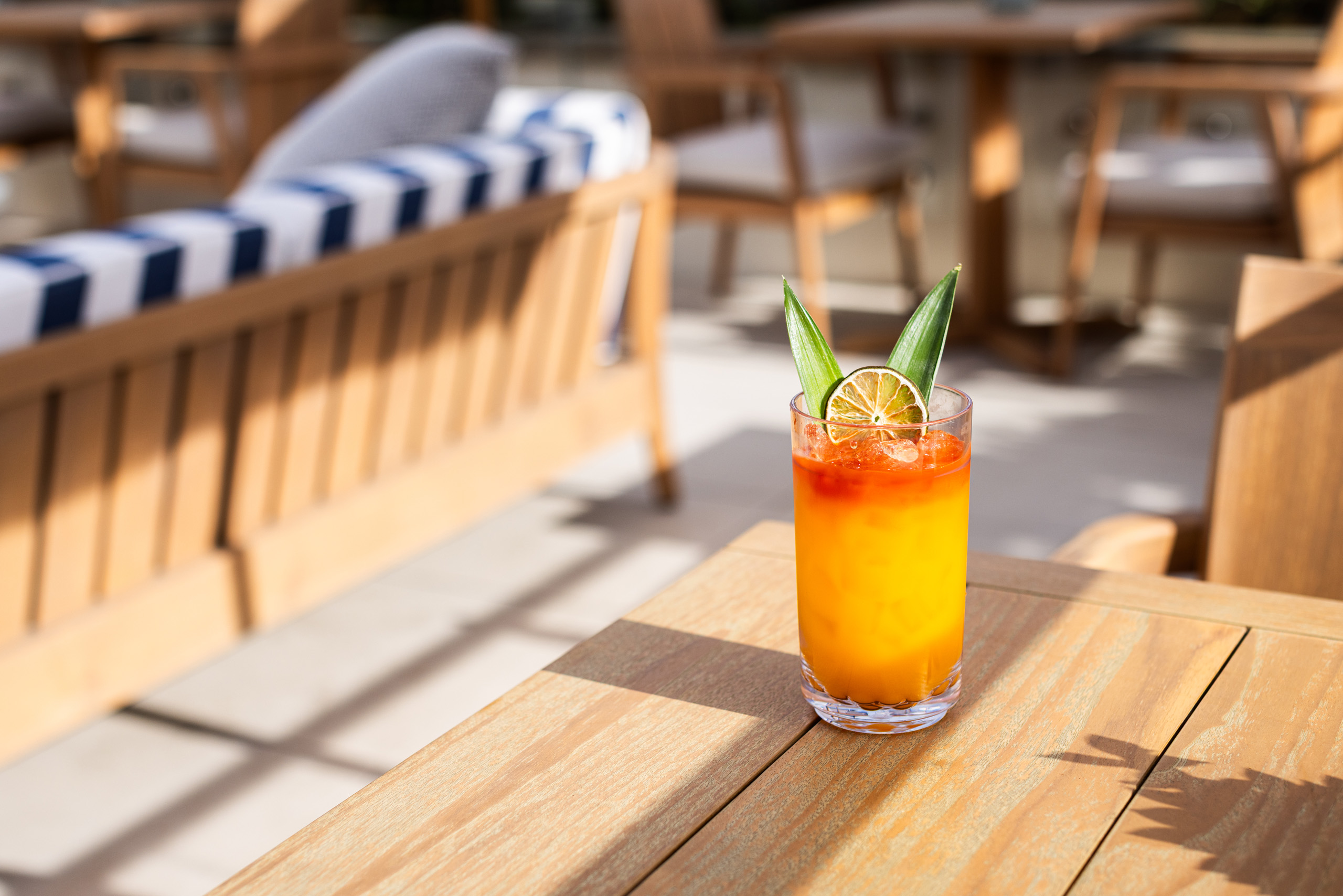 Tropical cocktail on wooden table in sunlit lounge