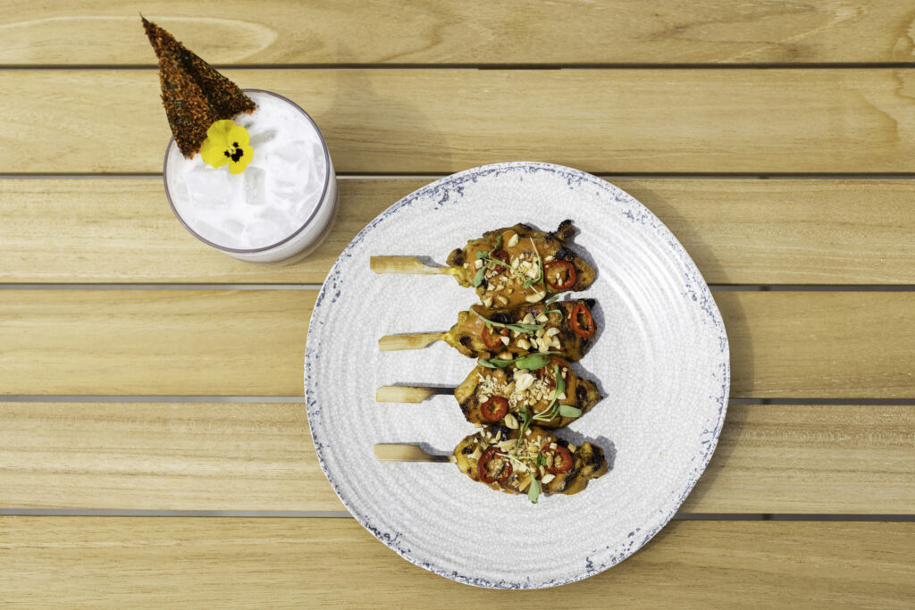 Grilled skewers on plate with creamy cocktail
