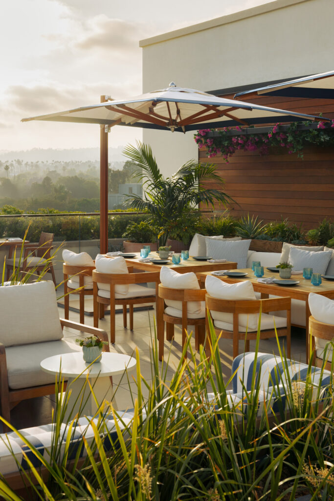 Rooftop dining setup with hillside views at golden hour.