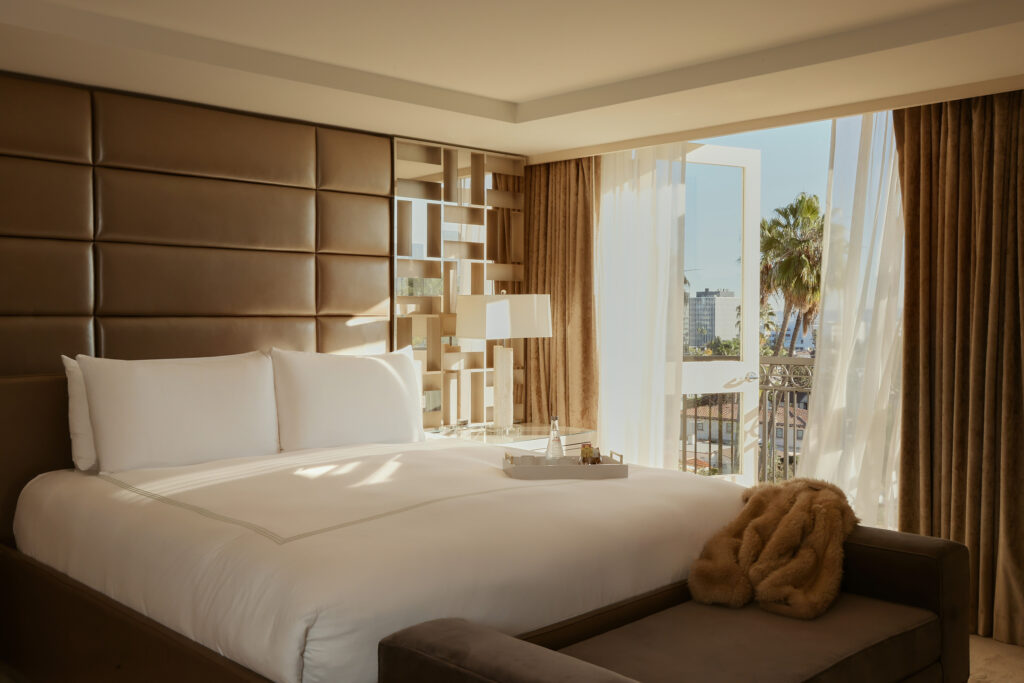Sunlit suite bedroom with balcony view and plush bed