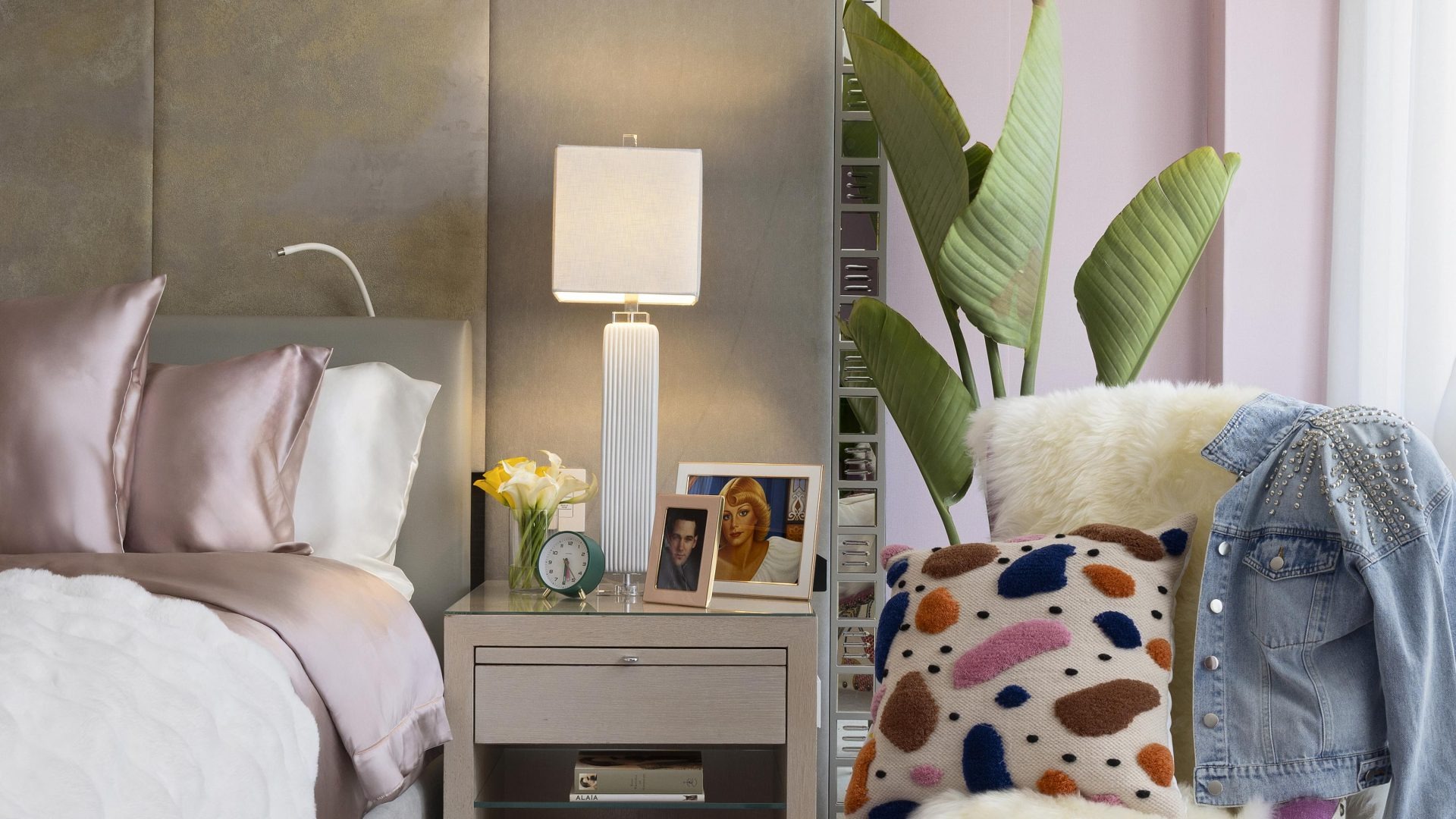 Bedside vignette with lamp, pillows, and plant