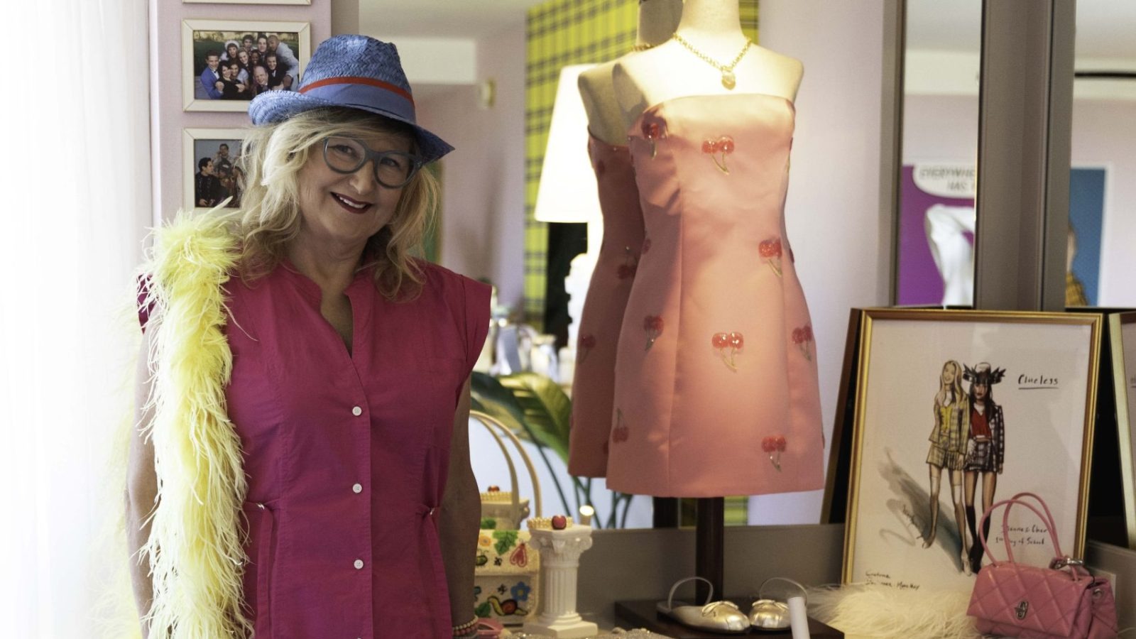 Designer posing beside Clueless-inspired dress display
