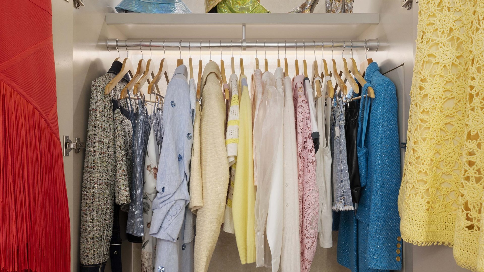 Closet full of colorful outfits on hangers